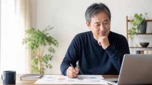 ノートパソコンで案件の計画を確認する50代のITエンジニア